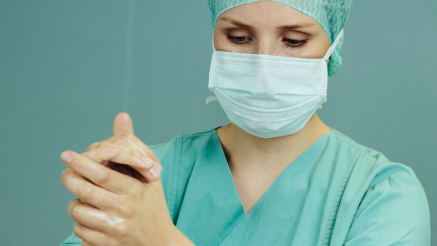 Female surgeon desinfecting her hands before surgery