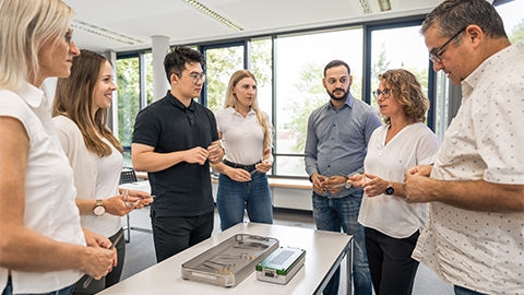 Eine Gruppe steht um einen Tisch mit aufbereiteten Medizinprodukten herum