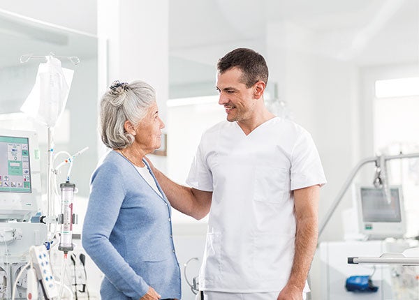 Eine Patientin befindet sich im Gespräch mit einem Pfleger.