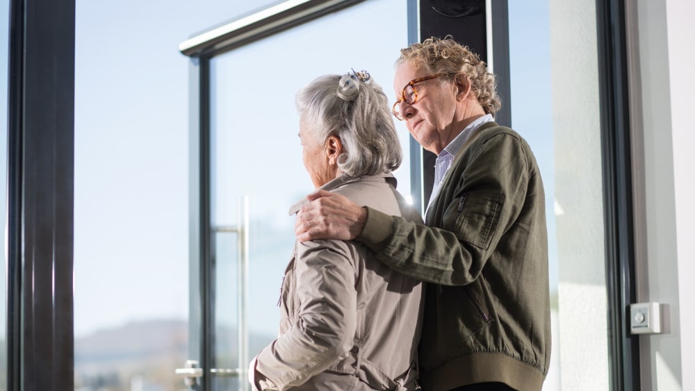 Mann legt Arm auf die Schulter der Frau