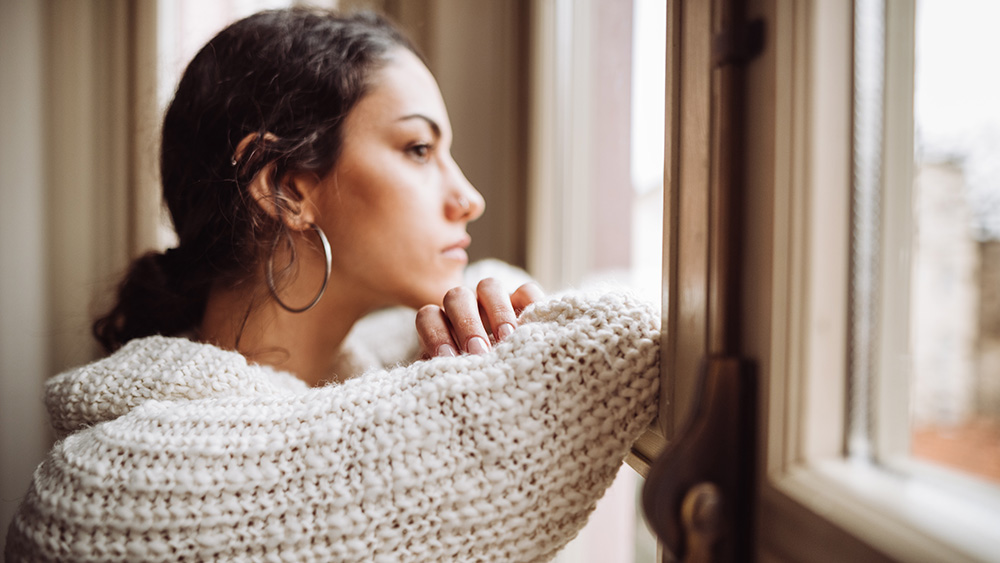 pensive woman in front of the window