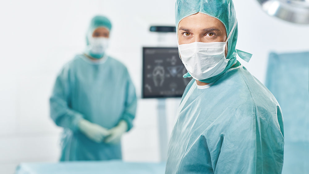 Zwei Chirurg*innen mit OrthoPilot® Elite im Hintergrund