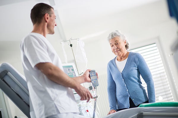 Patientin übt den Umgang mit der Dialysemaschine und wird dabei von einem Pfleger unterstützt.