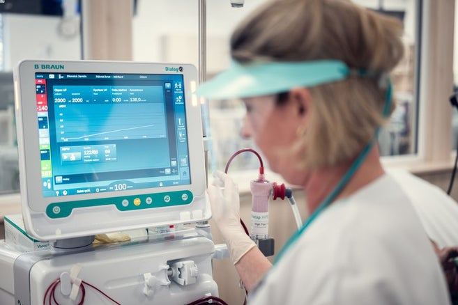 Eine medizinische Angestellte steht vor dem Bildschirm eines medizinischen Geräts