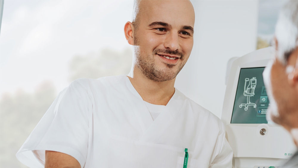 Pfleger, der mit einer Patientin spricht, die an ein Omni Gerät angeschlossen ist