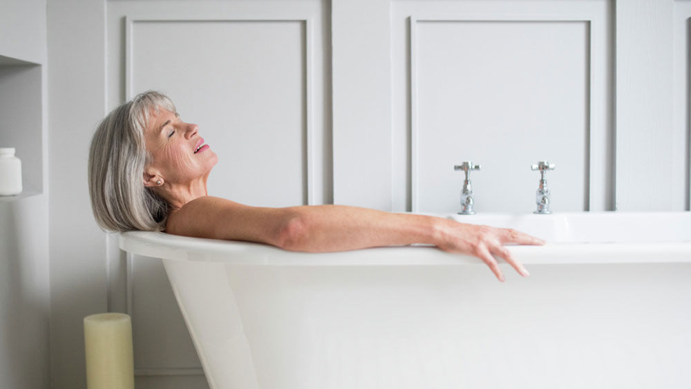 Eine Frau mittleren Alters liegt in der Badewanne