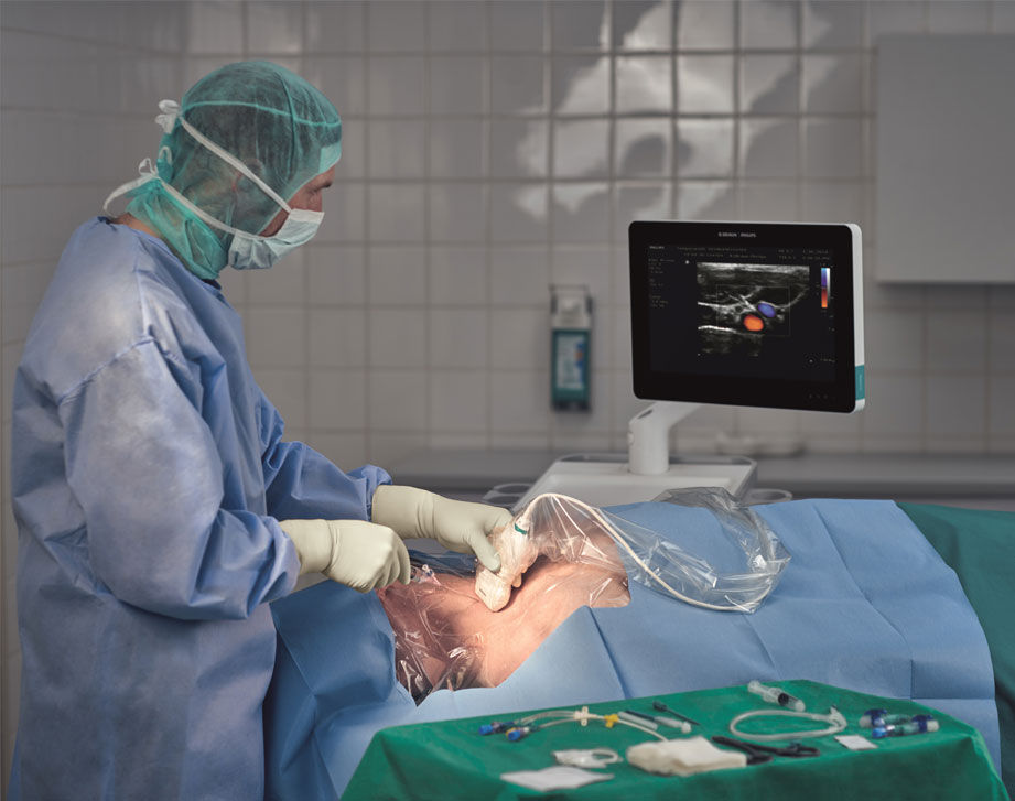 Platzierung der Venenkanüle mittels Ultraschall durch Arzt bei liegendem Patienten 