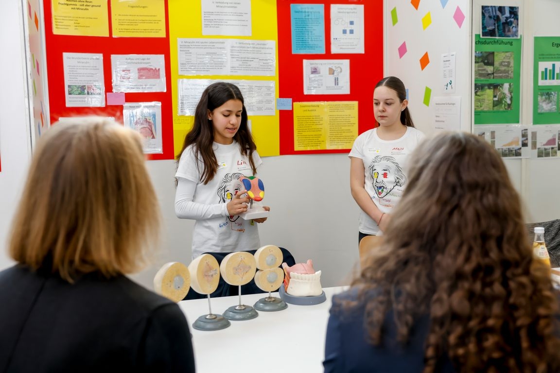 Zwei Kinder präsentieren anatomische Modelle bei einer Wissenschaftsausstellung