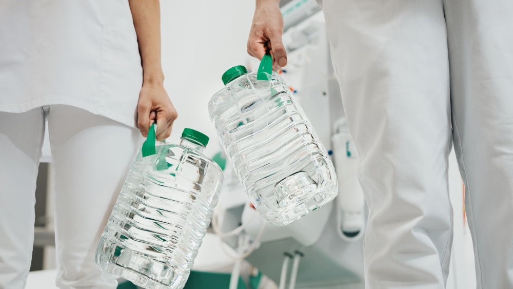 Zwei Pflegekräfte halten jeweils zwei Flaschen Sol-Can A in der Hand