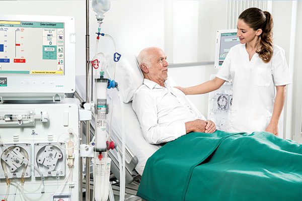 Pflegerin betreut einen Patienten während der Dialysebehandlung im Dialysezentrum.