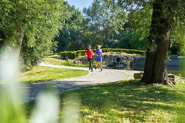 Bewegung bei Krebs: Patient joggt mit Freund im Park