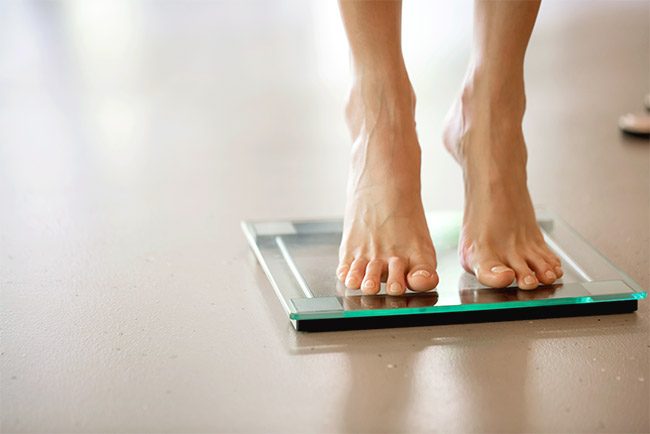 Füße auf Glaswaage: Gewichtsverlust durch Tumorkachexie