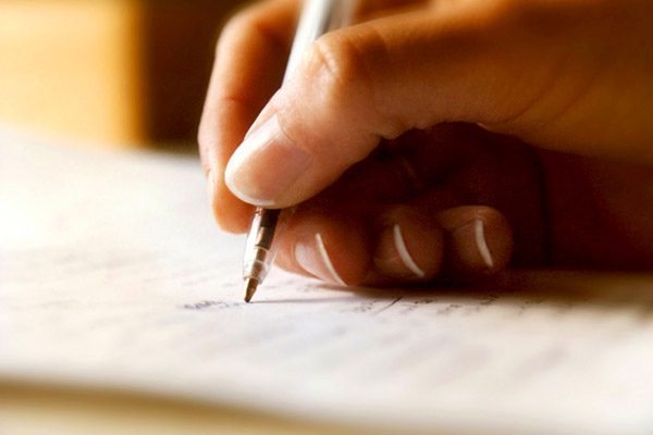 Beispielbild Ernährungstagebuch: Schreibende Hand mit Stift und Papier