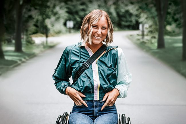 Eine Frau im Rollstuhl lächelt.