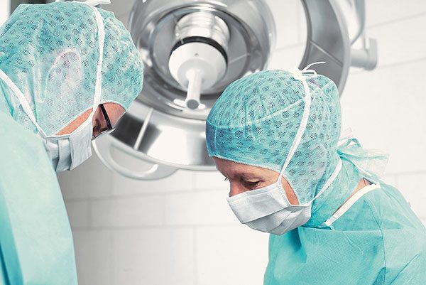 Zwei Chirurgen in steriler Kleidung in einer OP-Umgebung