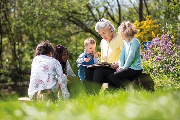Frau sitzt im Kreise Ihrer Enkelkinder