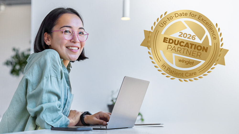 Person arbeitet an einem Laptop an einem Schreibtisch, daneben ein goldener Badge, der die Winglet-Bildungspartnerschaft darstellt