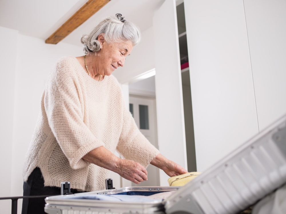 Ältere Frau bereitet Koffer vor
